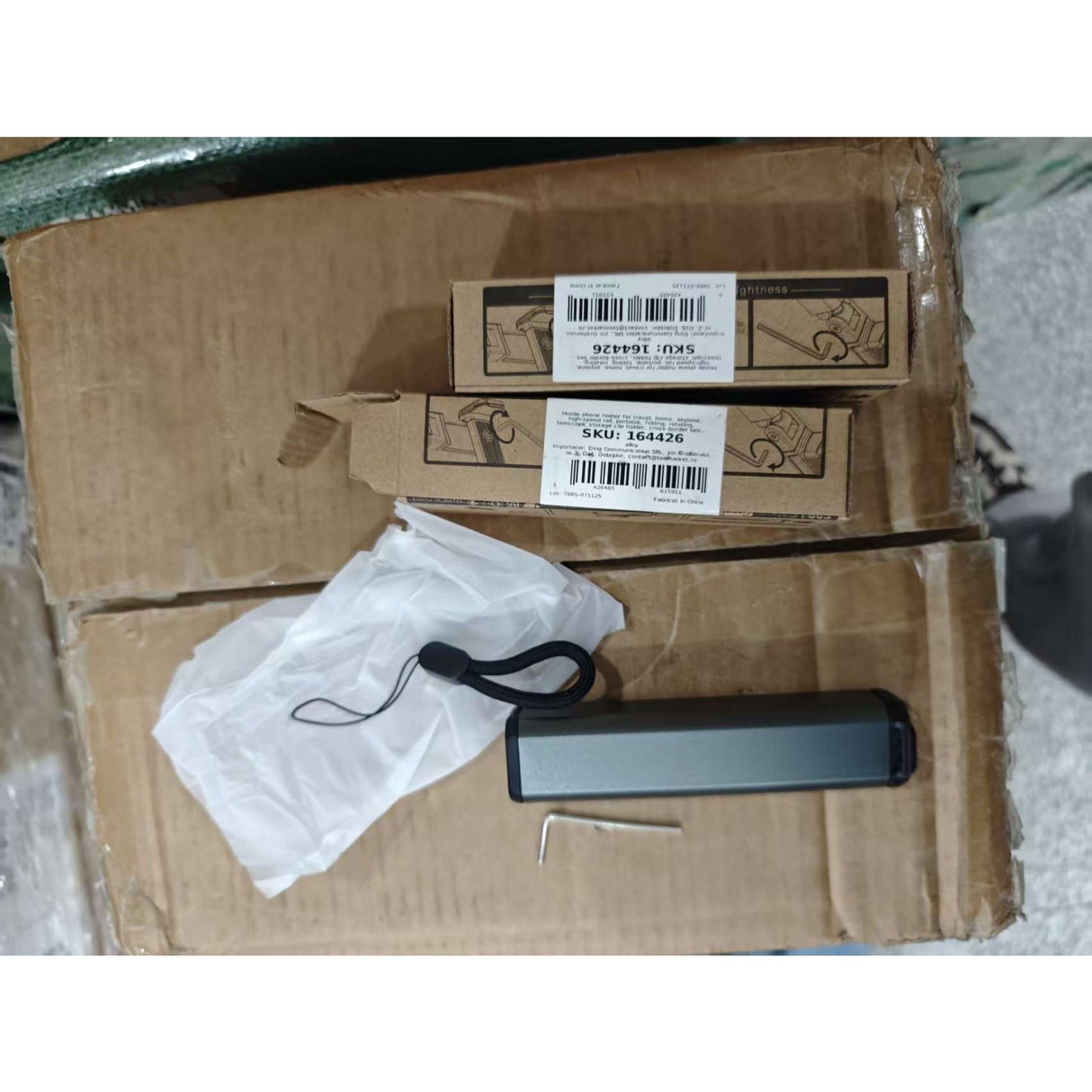 Suport telefon portabil negru pliat compact, detaliu mecanism telescopic și articulație rotativă