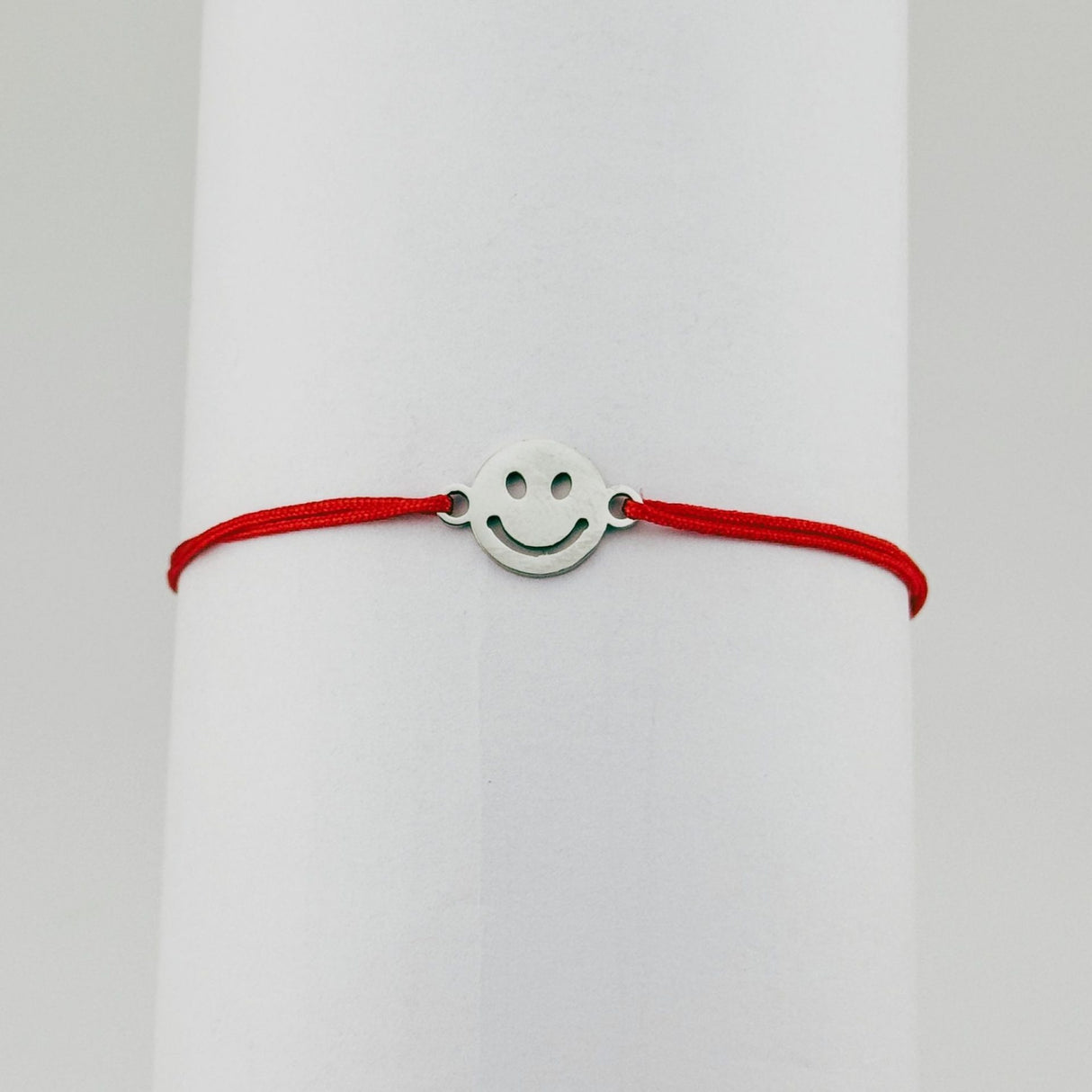 Brățară mărțișor Jolie Model Smile purtată pe încheietură, șnur roșu și pandantiv argintiu
