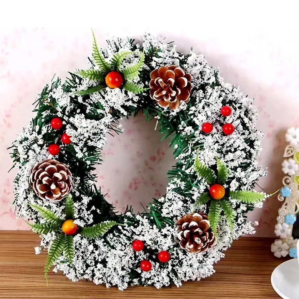 Karácsonyi koszorú, átmérője 20 cm, műfenyőből, tobozokkal és áfonyával díszítve, havas, /fehér