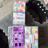 Dispenser bandă adezivă violet în utilizare pe birou, design compact și stabil