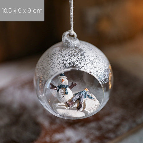 Detaliu fulgi albi decorativi pe suprafața globului de Crăciun model Om de Zăpadă și Omuleț