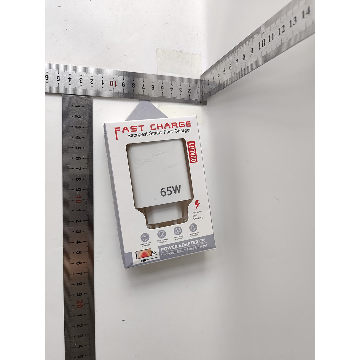 Încărcător rețea compact alb 65W în mâna utilizatorului, evidențiind dimensiunea portabilă