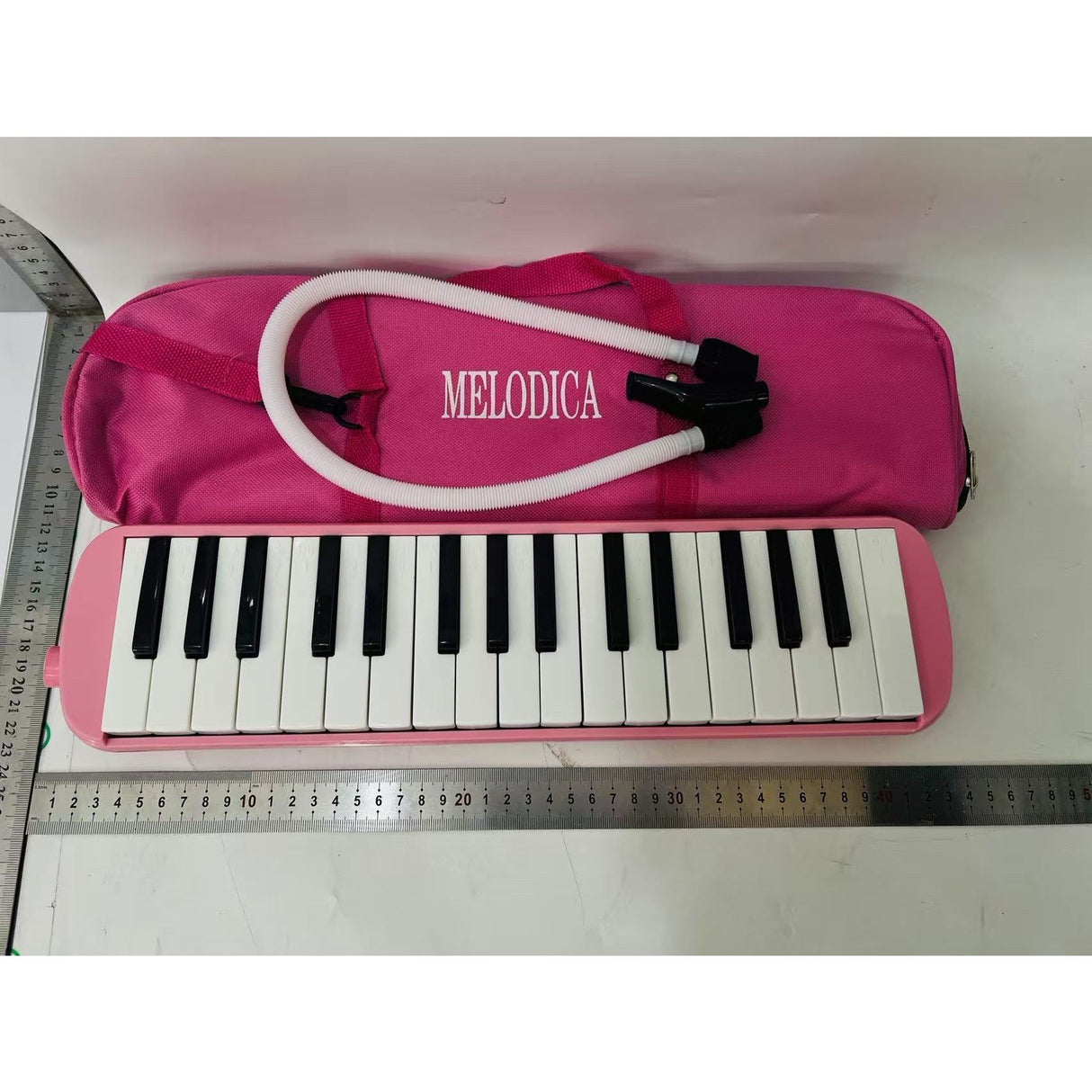 Muzicuță melodică roz 32 clape în husă de transport, perspectivă laterală, instrument vânt pentru începători