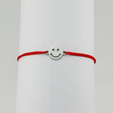 Brățară mărțișor Jolie Model Smile purtată pe încheietură, șnur roșu și pandantiv argintiu